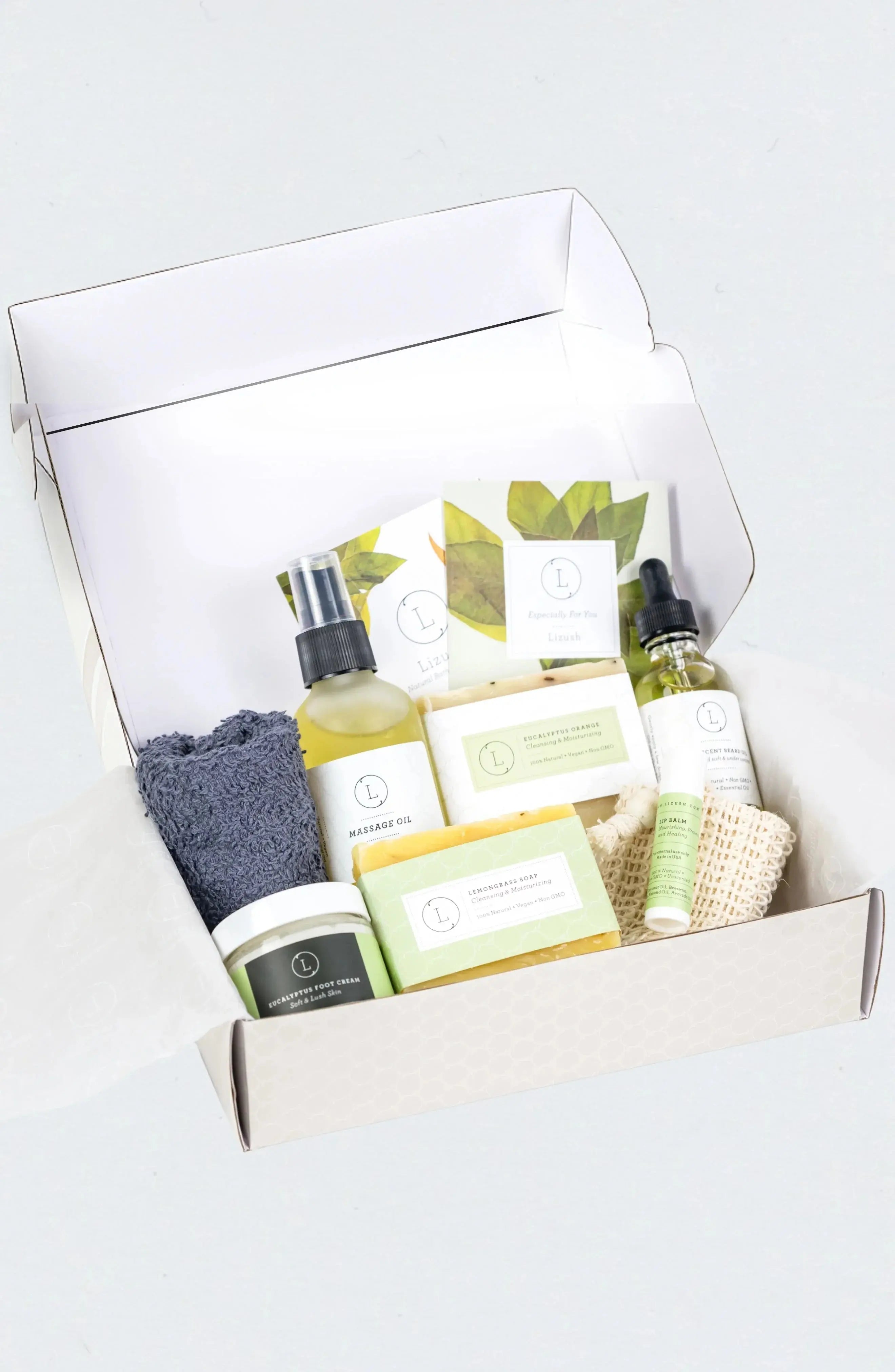 Cozy self-care gift box with natural bath essentials, massage oil, soap, foot cream, and loofah for relaxation