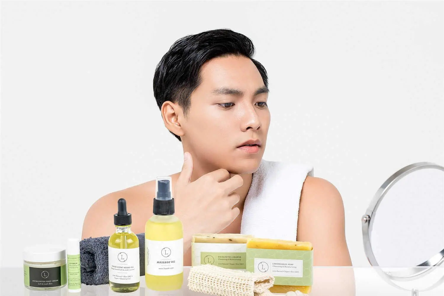 Man applying beard oil and skincare products, featuring natural soaps and massage oil for men's grooming routine