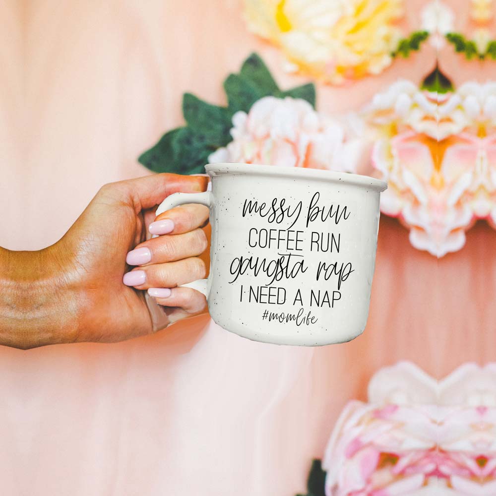 Person holding a mug with text in front of flowers