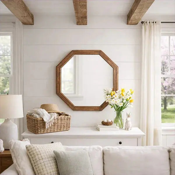 Rustic octagon wood mirror above white console in cozy farmhouse living room with floral vase and wicker basket