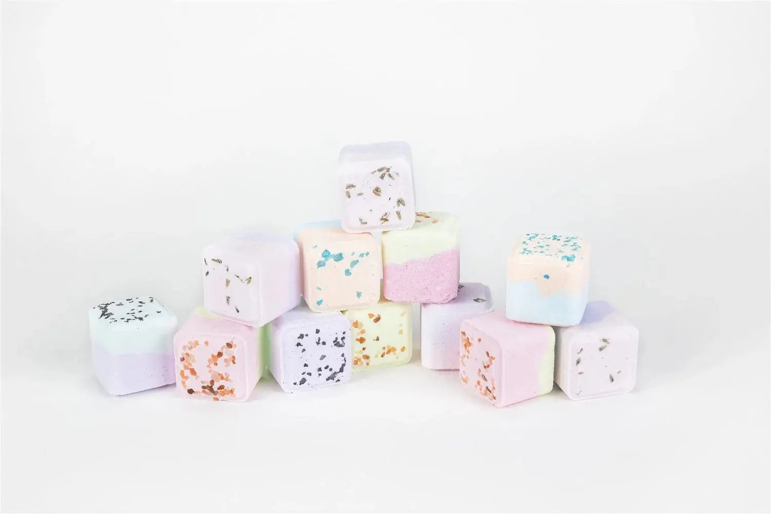 Pastel bath bombs with glitter and herbs, perfect for cozy farmhouse bath essentials.