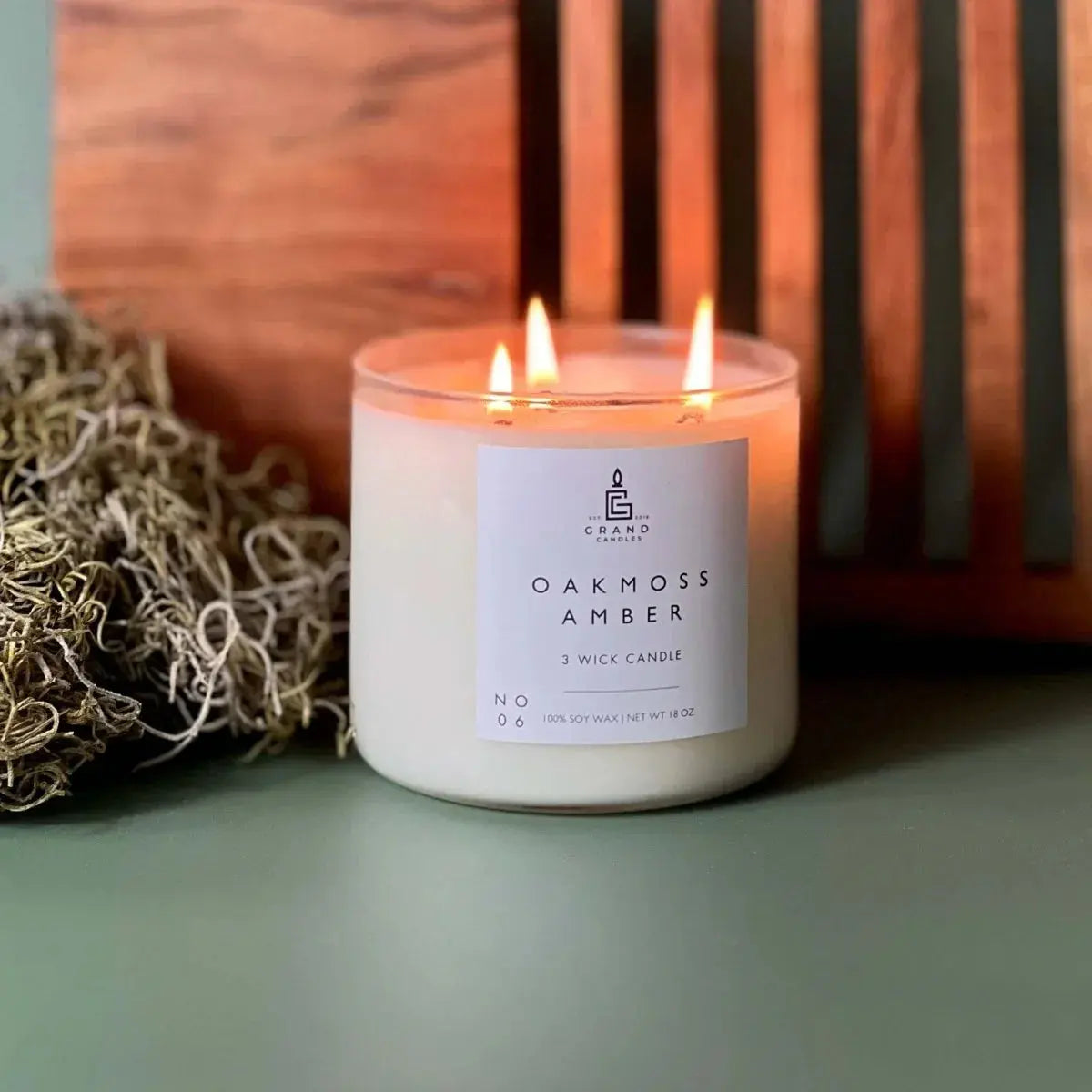 Oakmoss Amber 3-wick soy candle with warm glow, cozy farmhouse decor