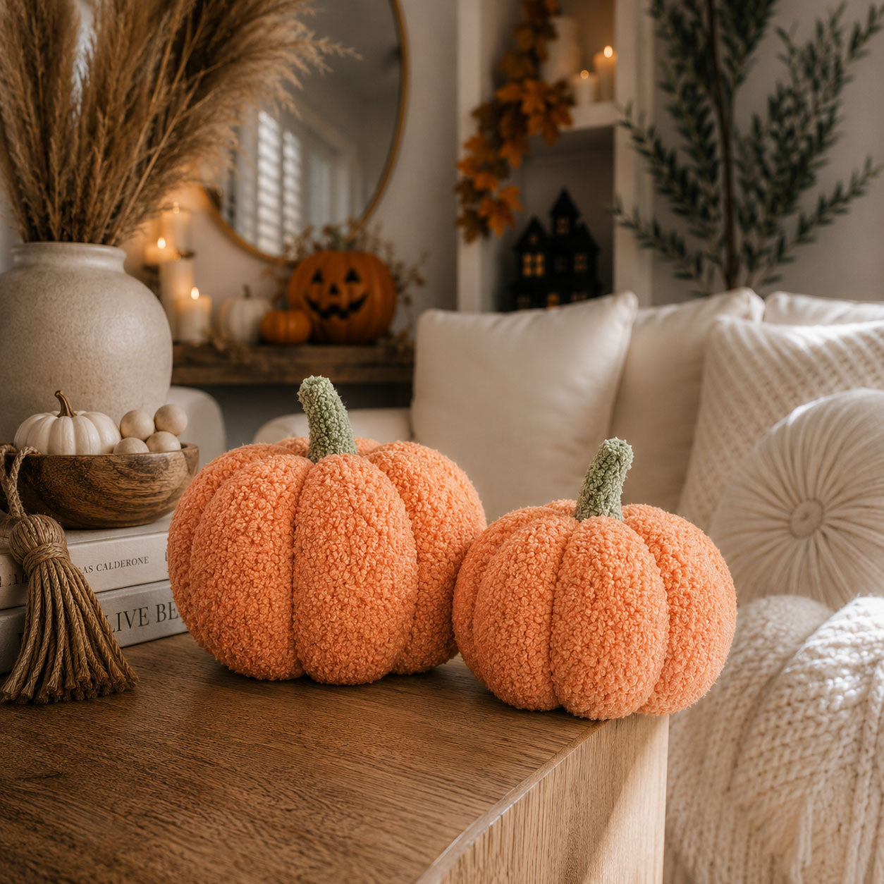 Decorative pumpkins on a wooden surface with a cozy living room background.