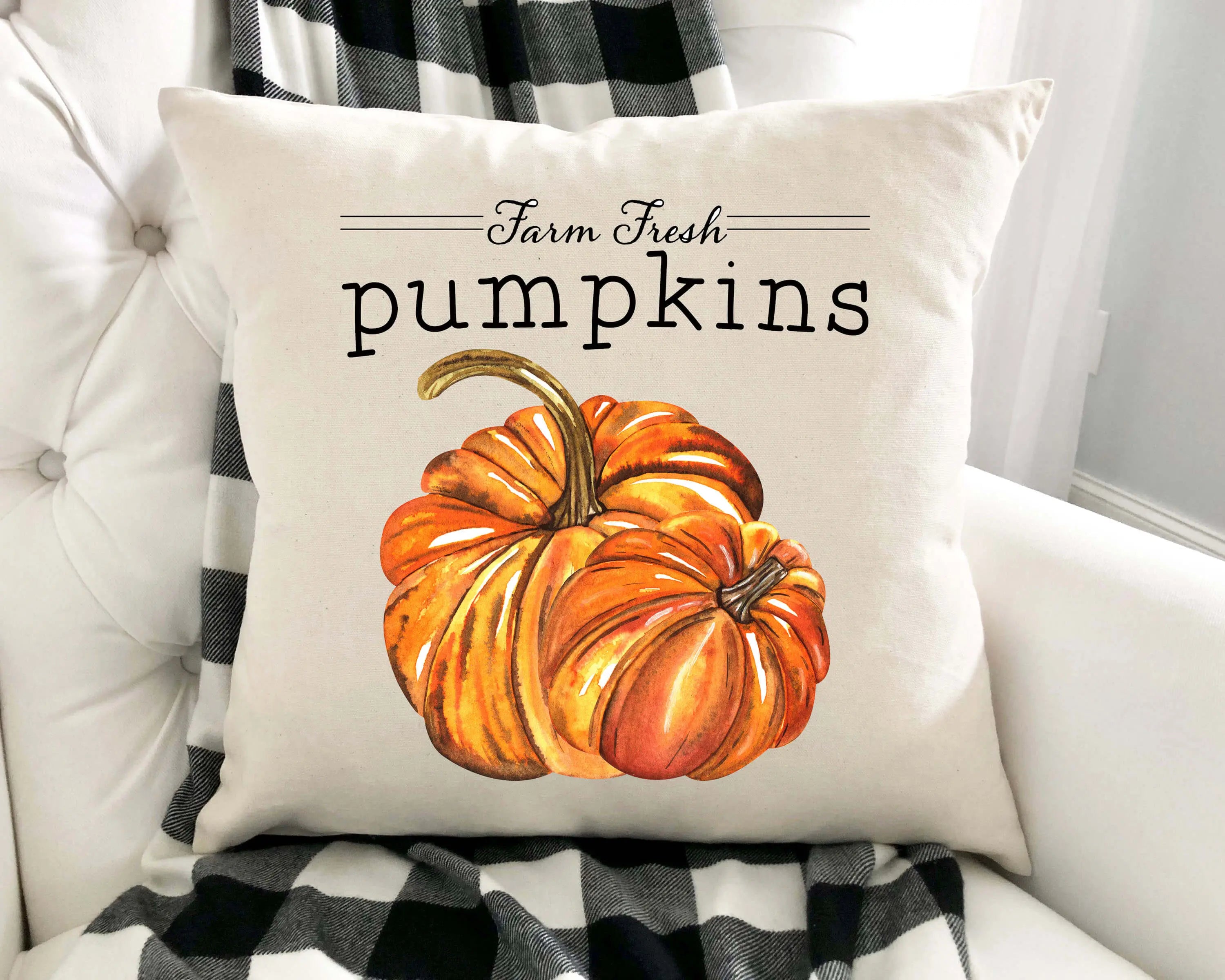 Decorative pillow with a pumpkin design and 'Farm Fresh Pumpkins' text on a white couch.