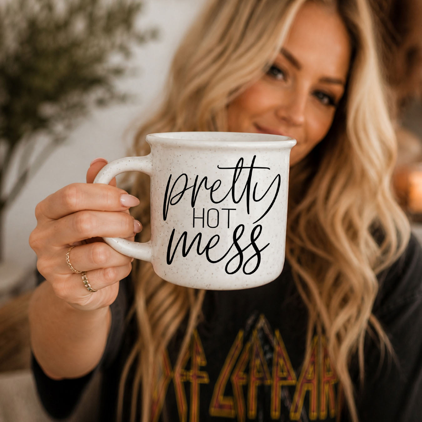 Person holding a mug with 'Love You Bitch' text, blurred background
