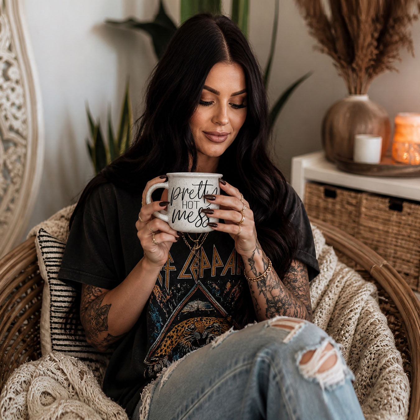 Woman holding a mug with text, sitting in a cozy room with plants and decorative items.