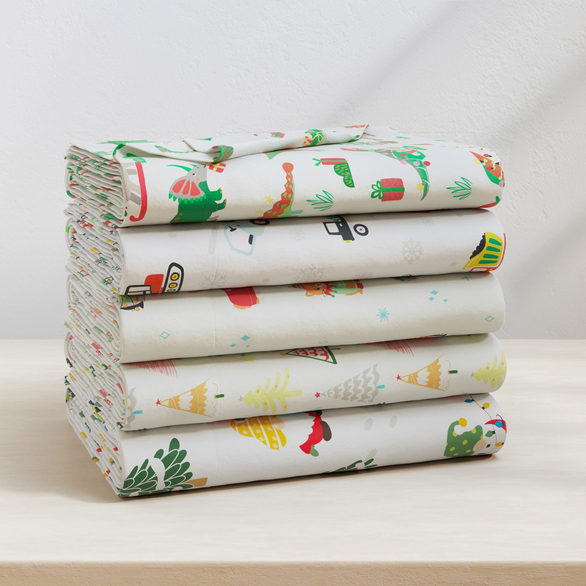 Stack of colorful fabric sheets with cartoon patterns on a white surface.