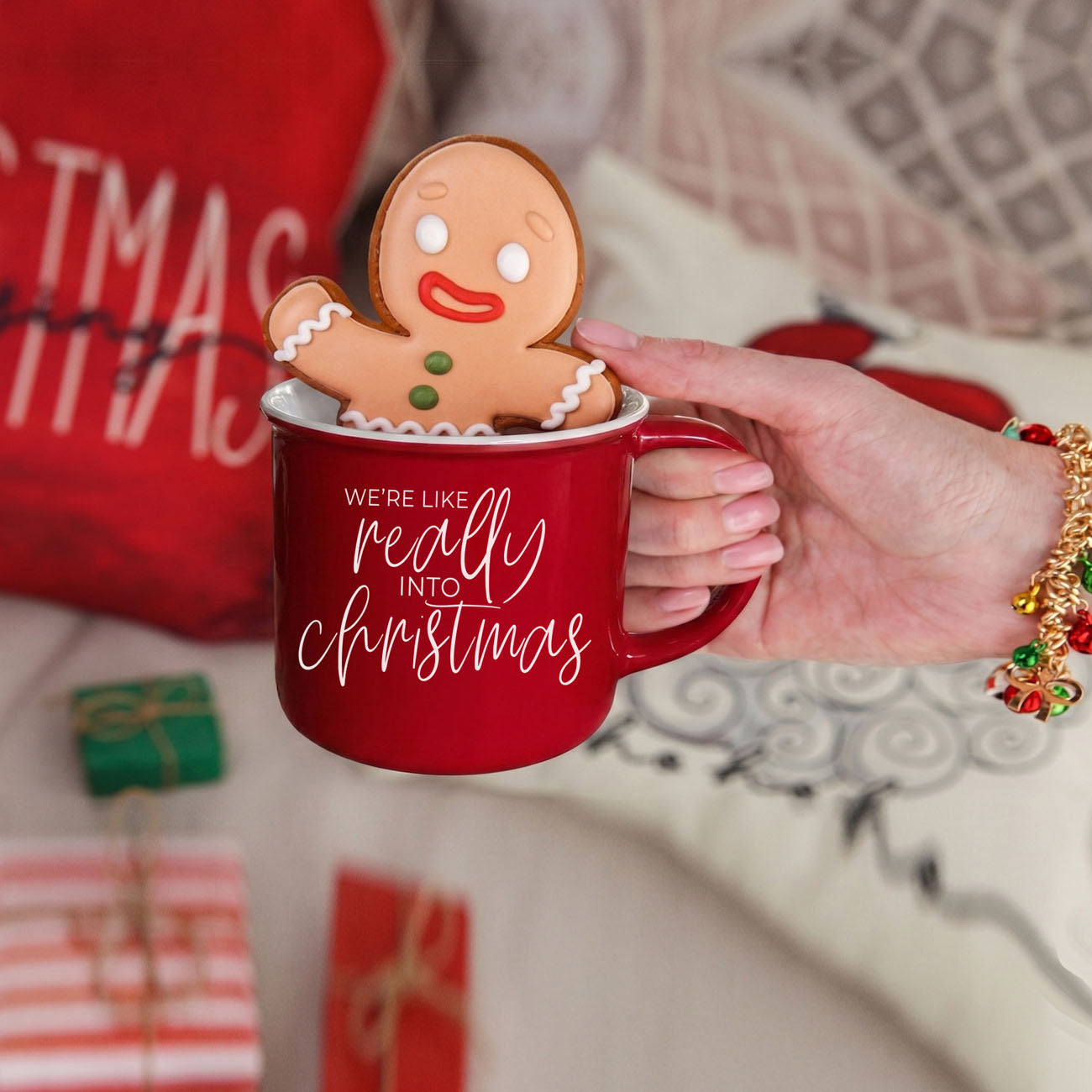 Red mug with gingerbread man and 'We're like really into Christmas' text, held by a hand.