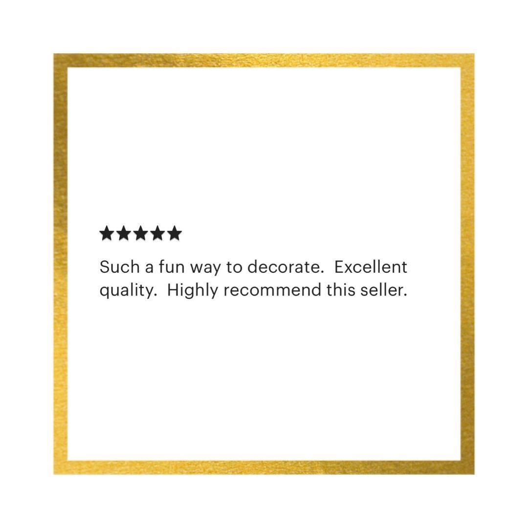 A square white card with a metallic gold border, featuring a five-star rating and a customer review in black text that reads: 'Such a fun way to decorate. Excellent quality.