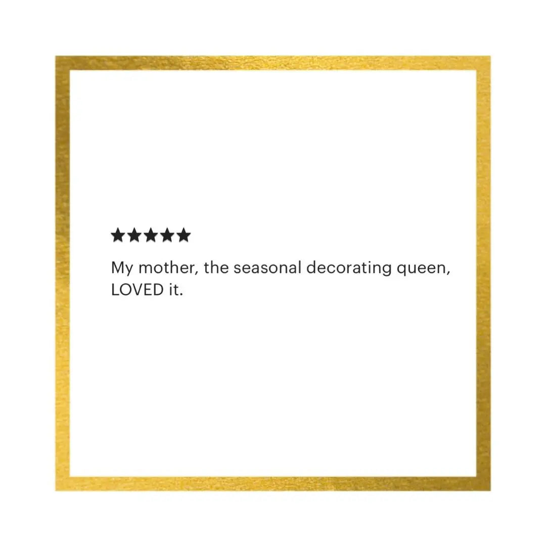 A square white card or print with a metallic gold border, featuring a five-star rating graphic and the text: 'My mother, the seasonal decorating queen, LOVED it.' on a white background.