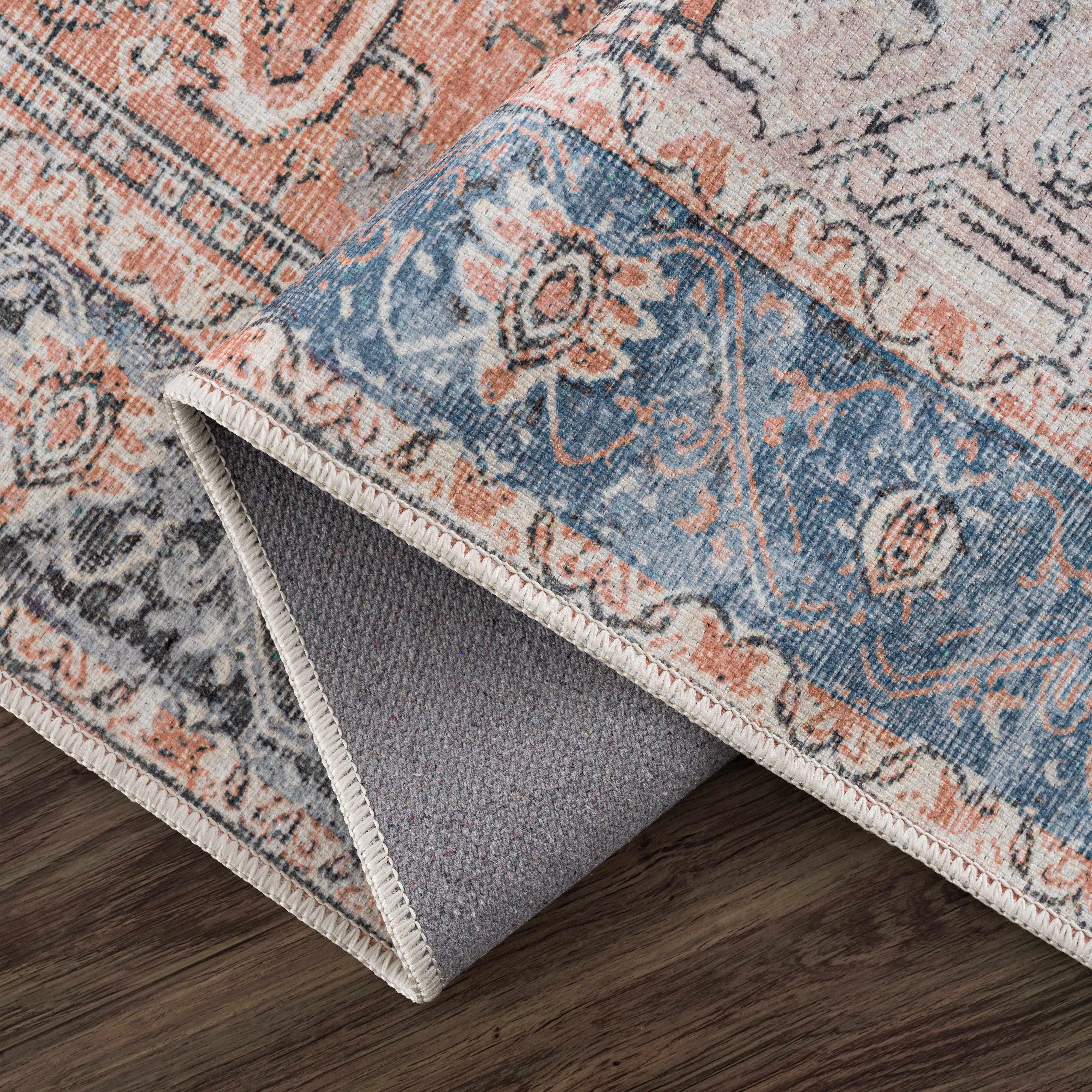 Vintage-style area rug with blue, pink, and gray boho pattern, perfect for cozy farmhouse decor on wood floors.