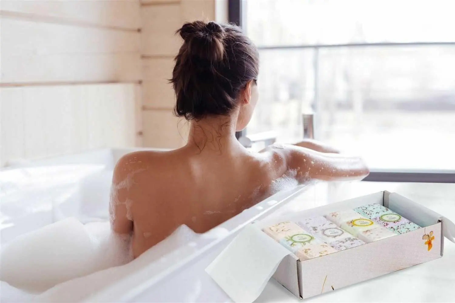 Woman relaxing in a bubble bath with artisan soap set, cozy farmhouse bath essentials