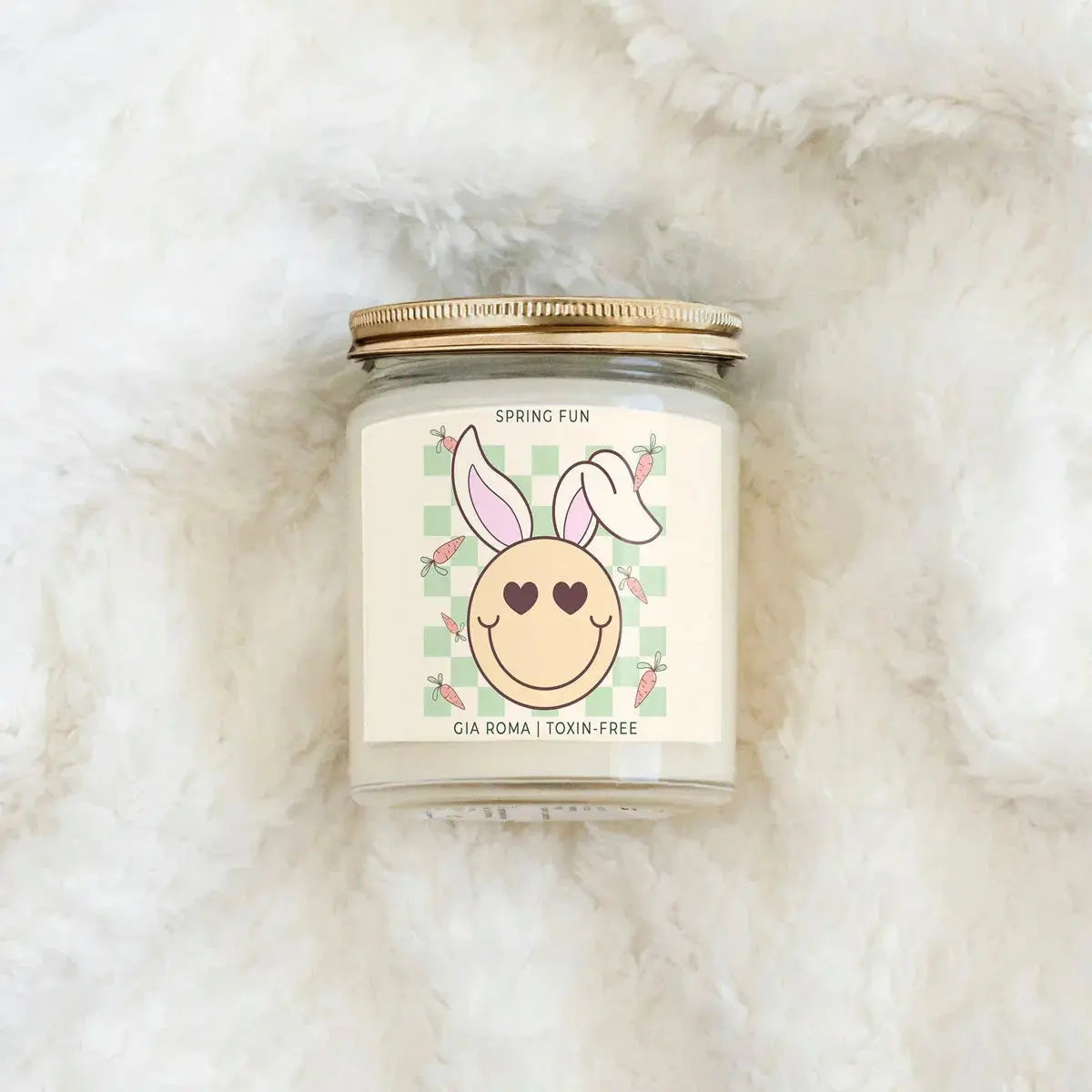 Candle jar with a decorative label on a fluffy white surface