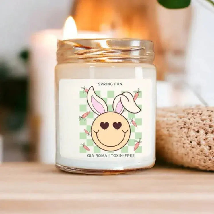 Candle in a jar with a bunny design label on a wooden surface