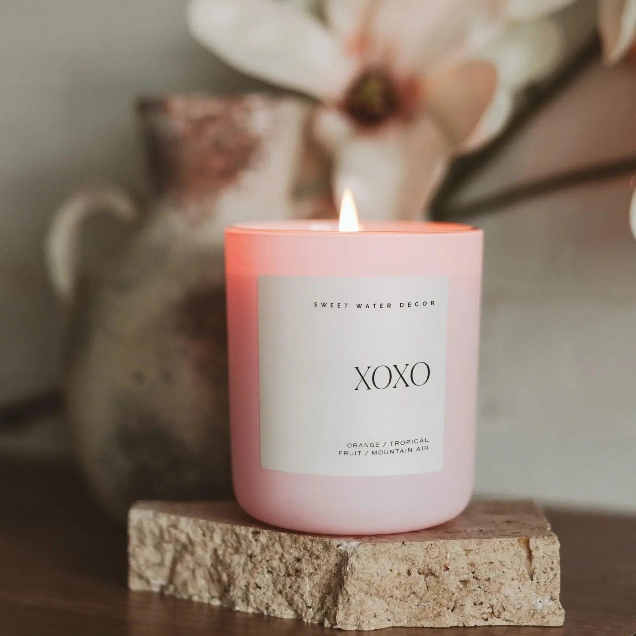 Pink XOXO scented candle with orange tropical fruit notes, cozy farmhouse decor