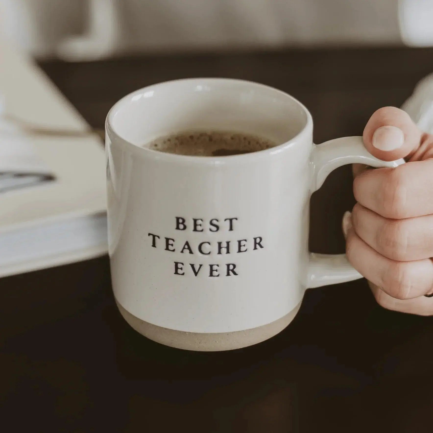 White ceramic mug with 'Best Teacher Ever' text, held in hand, cozy farmhouse style gift