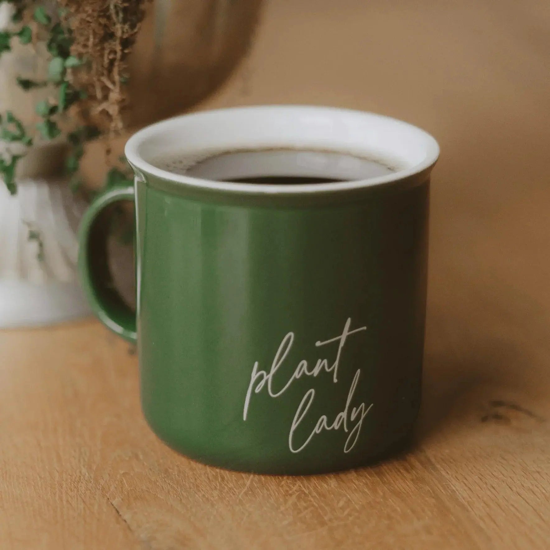 Green 'plant lady' mug with coffee on wooden table, cozy farmhouse decor