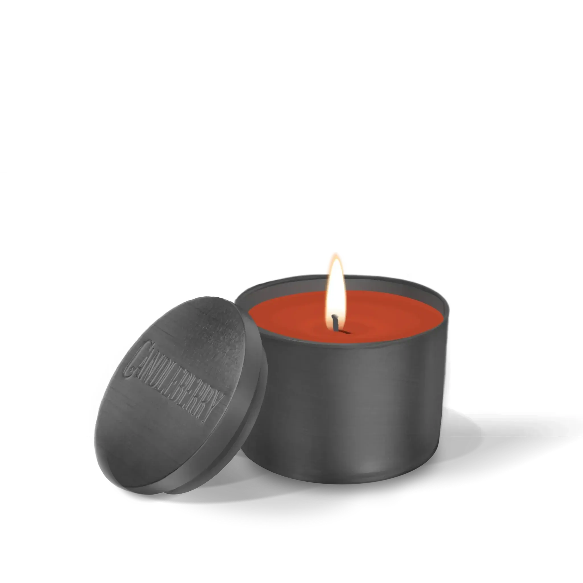 Lit orange candle in matte black tin with lid, cozy home decor essential for warm ambiance