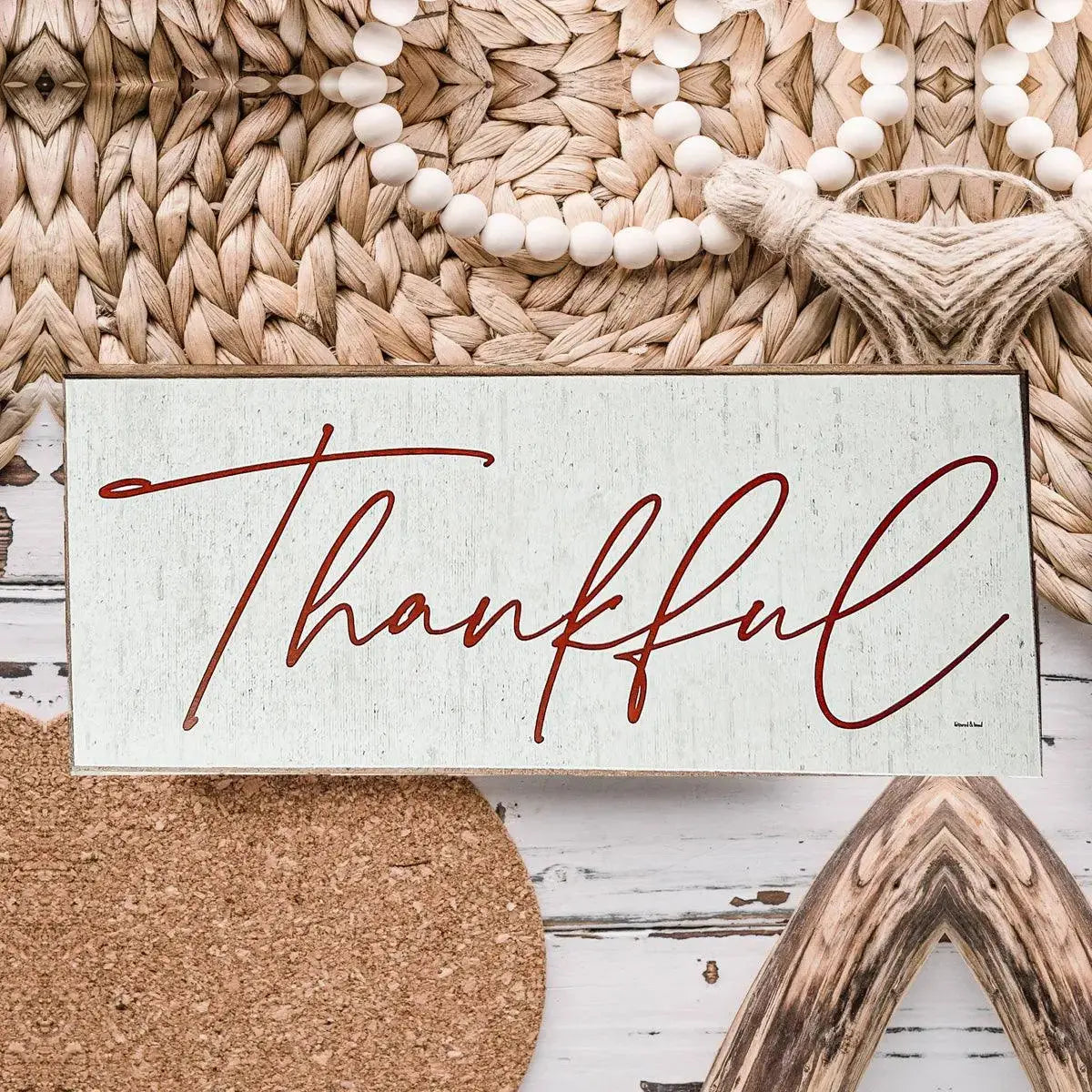 Decorative sign with 'Thankful' text on a rustic background