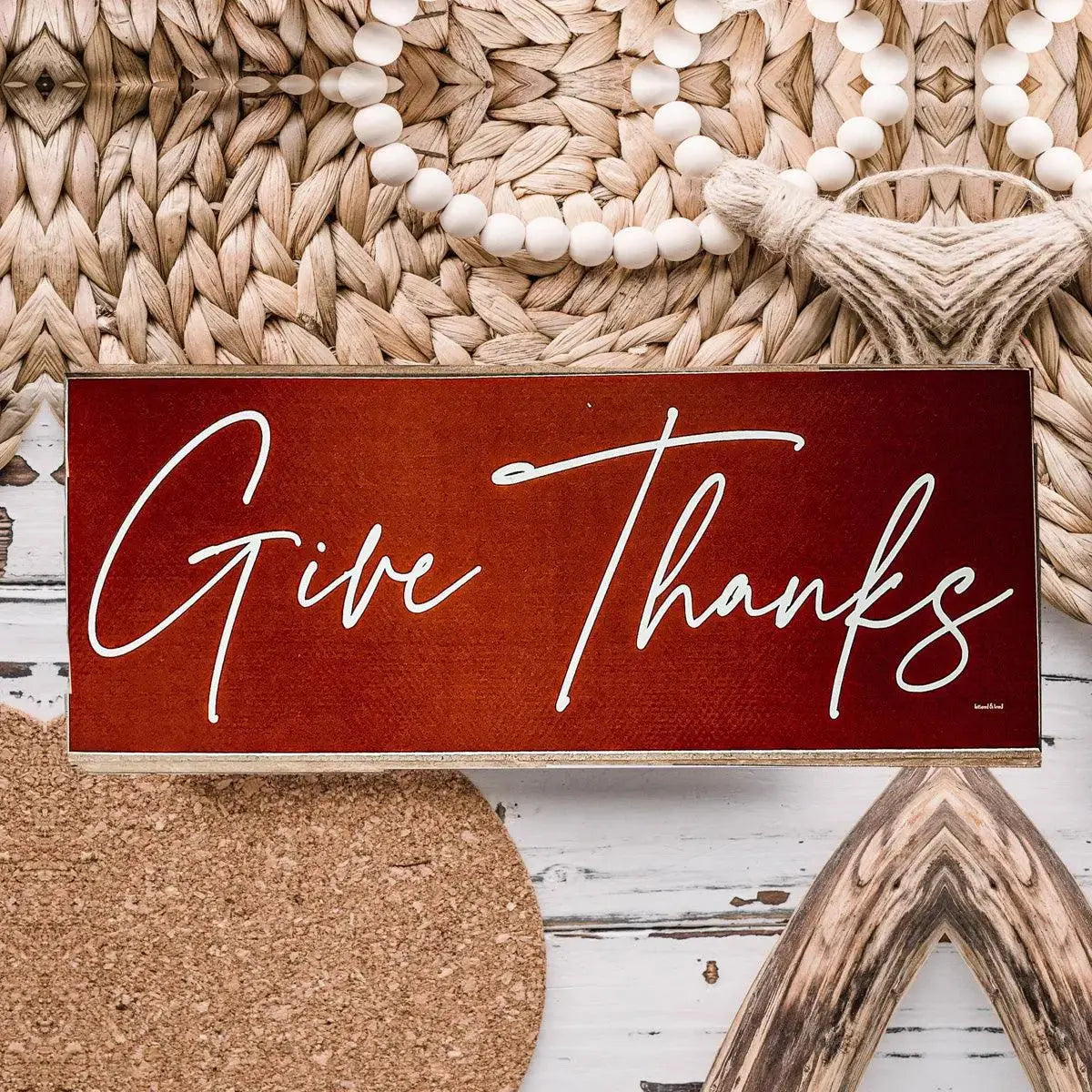 Decorative sign with 'Give Thanks' text on a rustic background