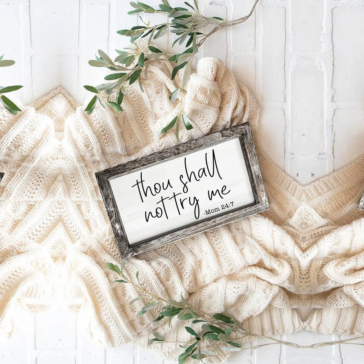 Decorative sign with text on a textured surface with greenery