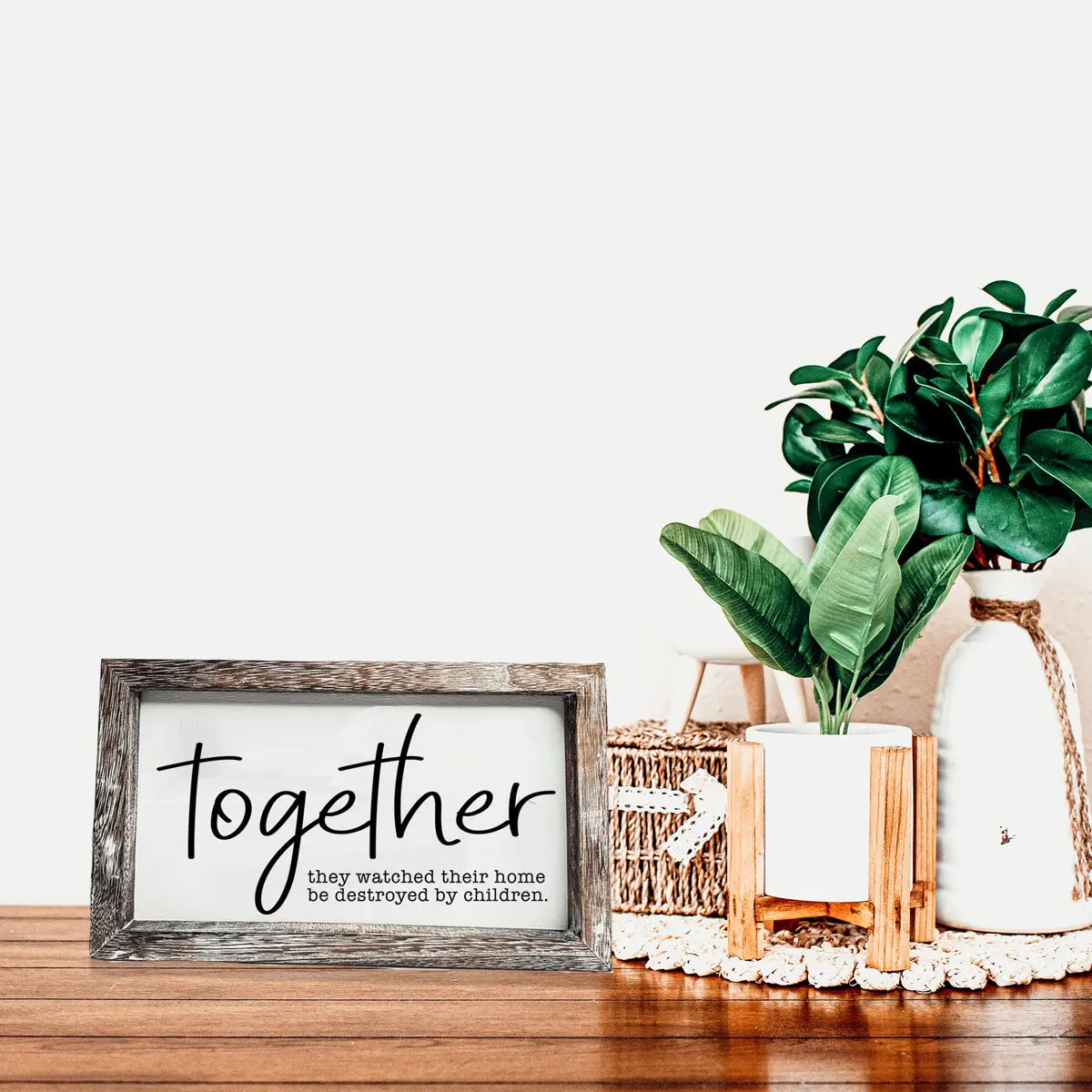 Decorative sign with 'thou shall not try me' text on a wooden surface with plants and decor items.