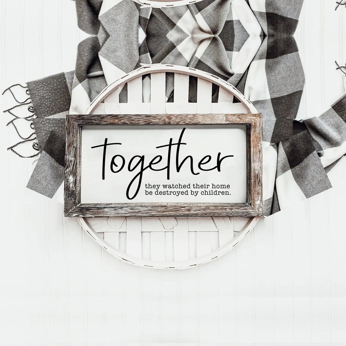 Decorative wall art with a wooden frame displaying the word 'Together' and text, against a patterned fabric background.