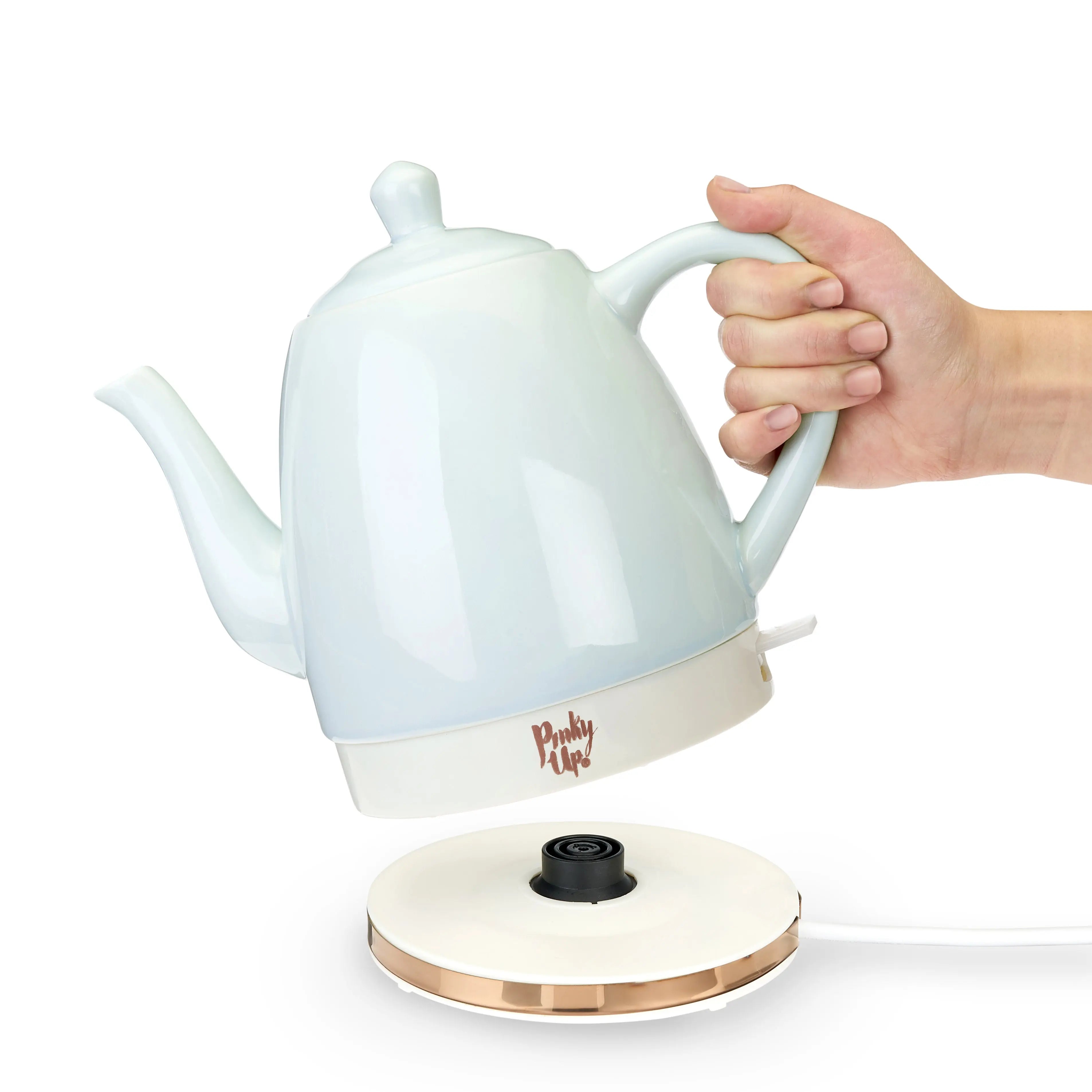 White electric kettle with a hand holding it on a white background