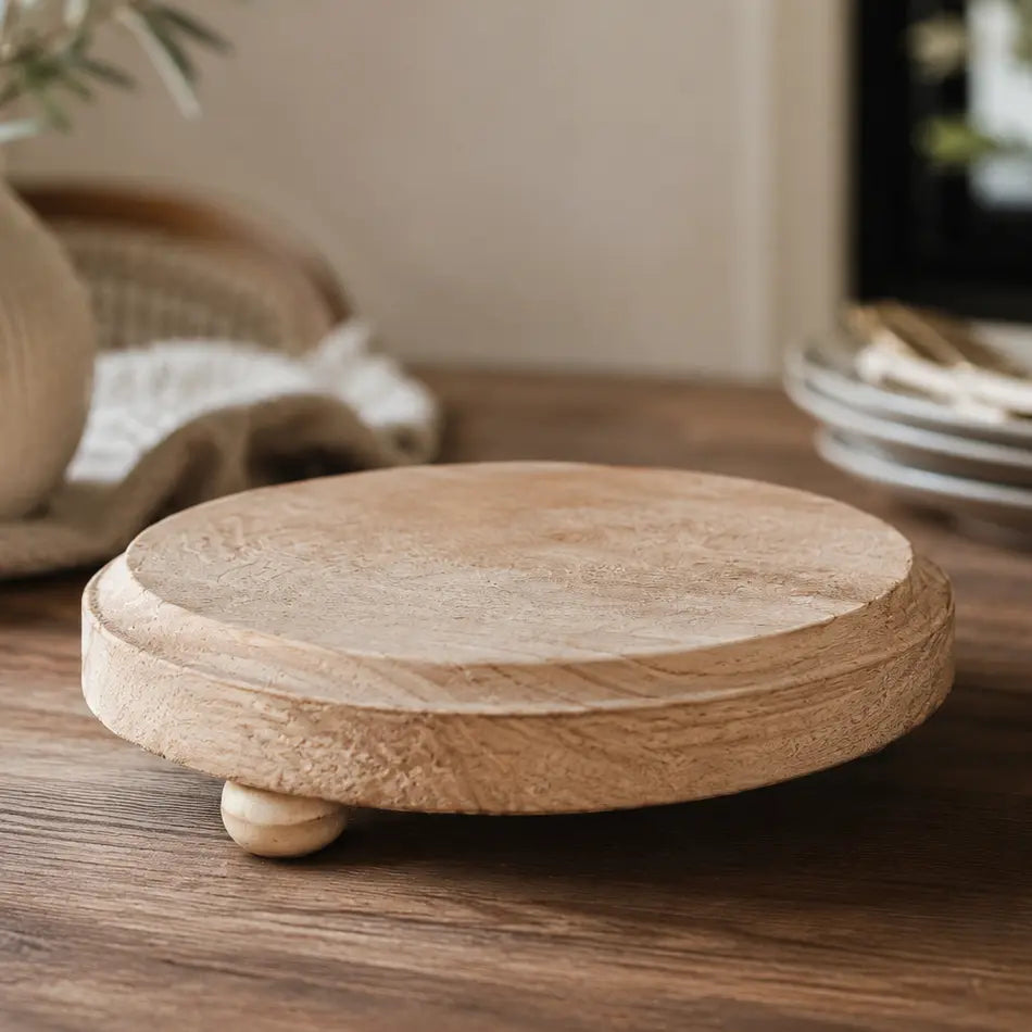 Round wooden coaster on a wooden surface with a blurred background