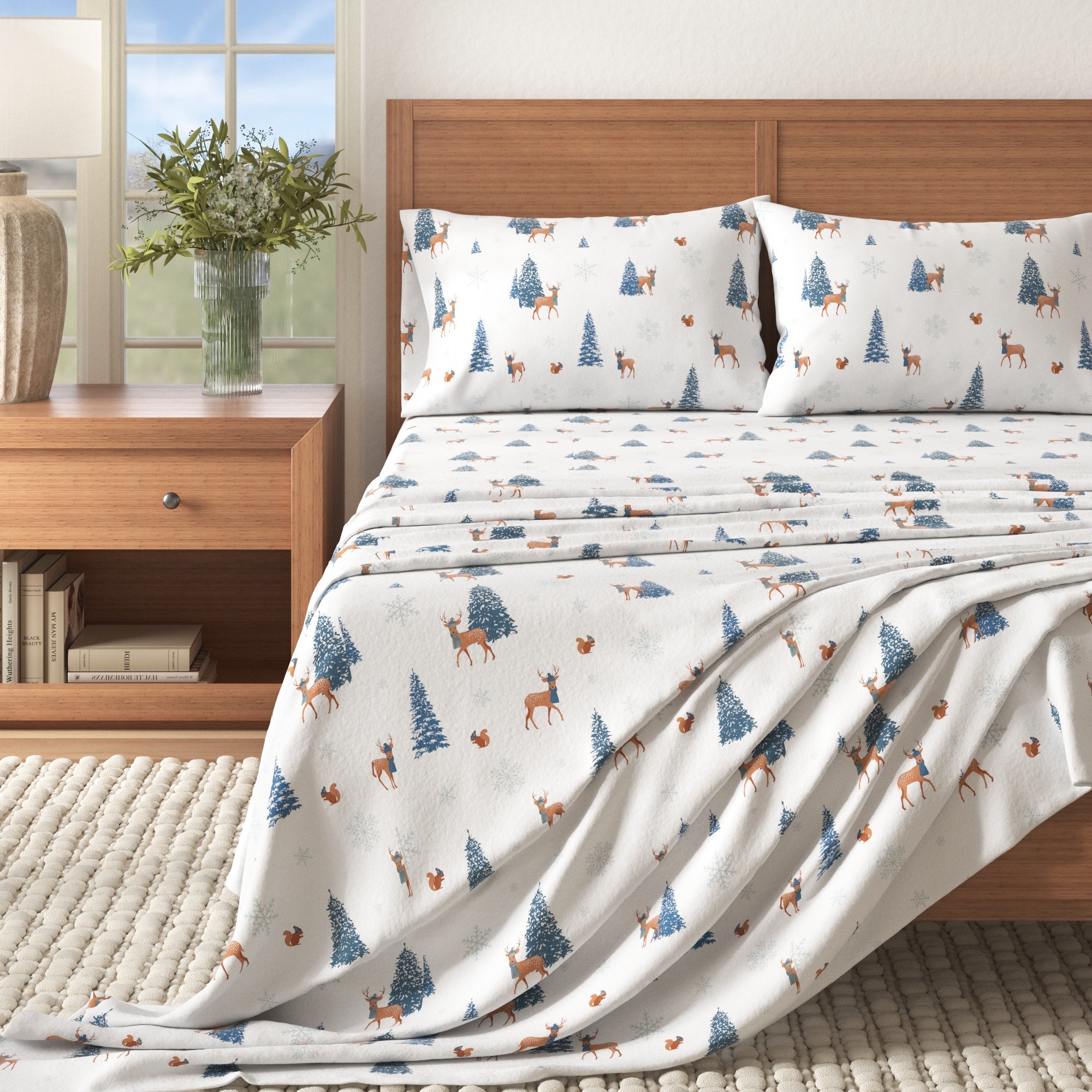 Bed with patterned bedding featuring deer and trees, next to a wooden nightstand with a plant.