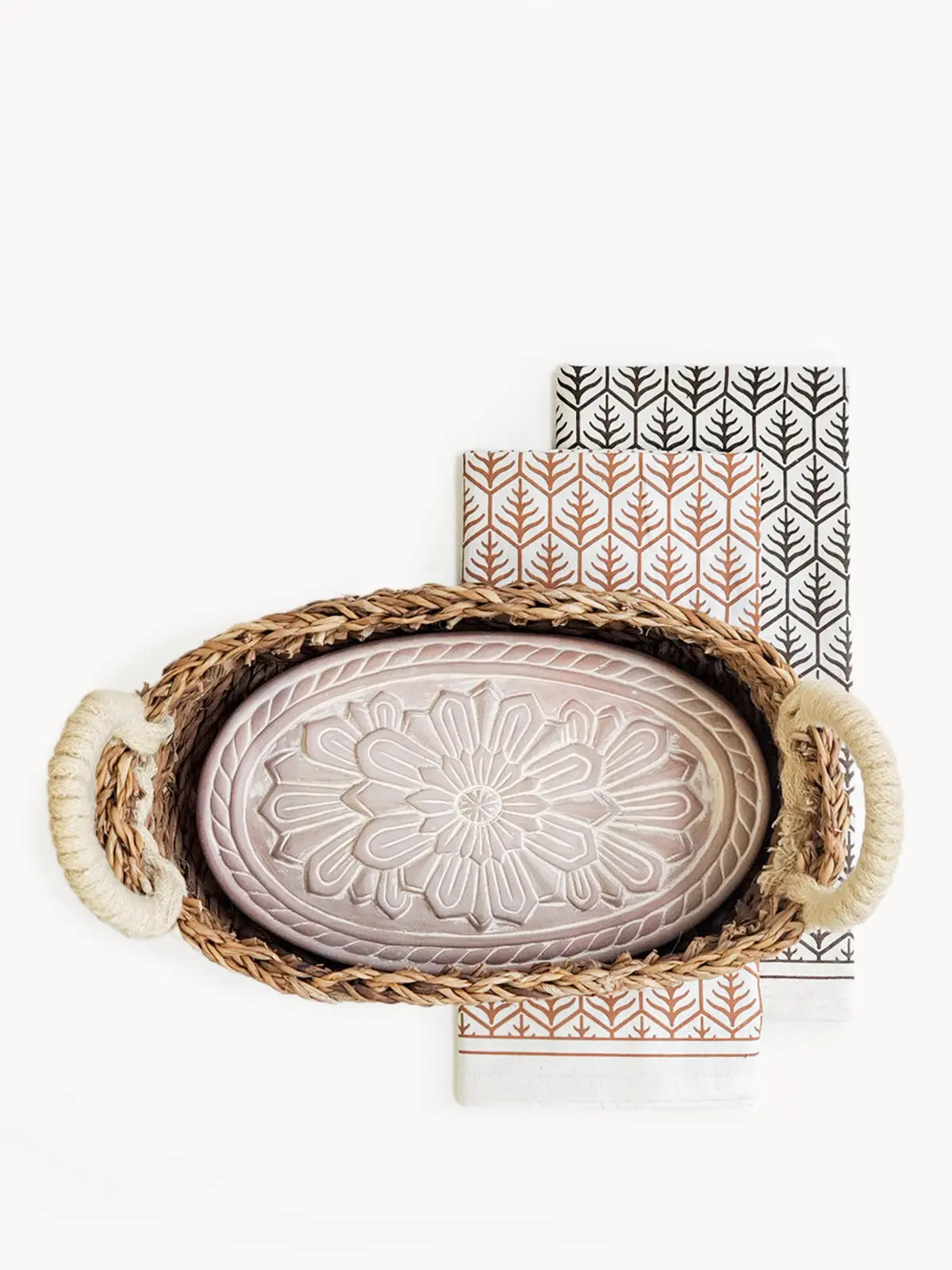 Woven tray with floral ceramic dish and patterned napkins for cozy farmhouse decor