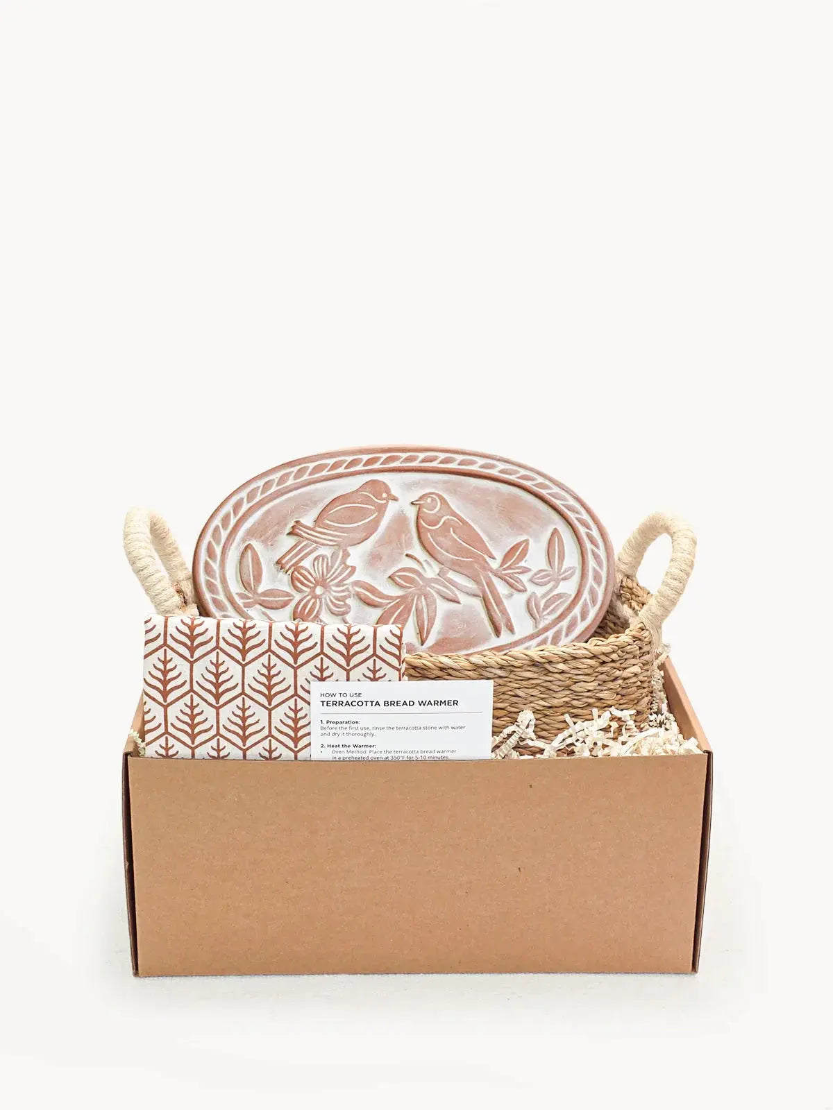 Terracotta bread warmer with bird design in woven basket, cozy farmhouse kitchen gift set