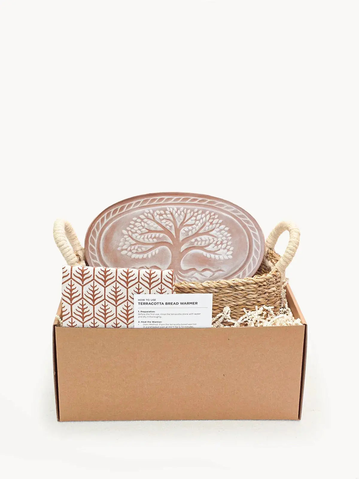 Terracotta bread warmer with tree design in woven basket, cozy farmhouse kitchen gift set