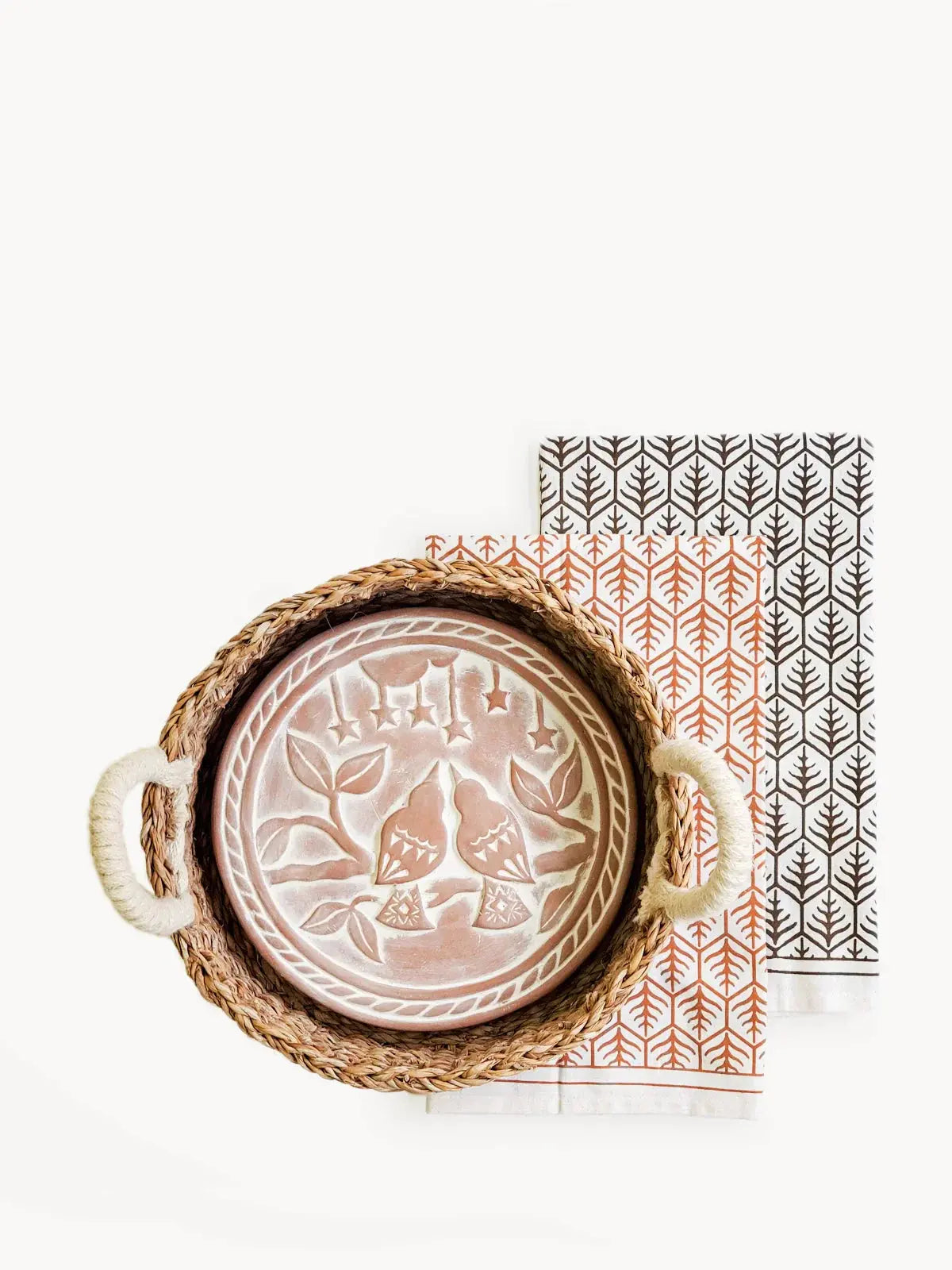 Woven tray with ceramic bird plate and patterned napkins for cozy farmhouse decor