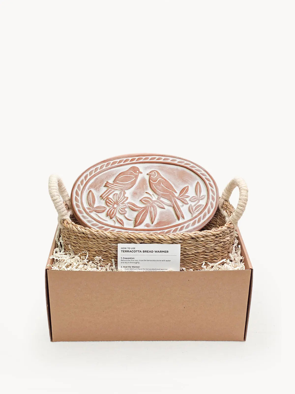 Terracotta bread warmer with bird design in woven basket, cozy farmhouse kitchen decor