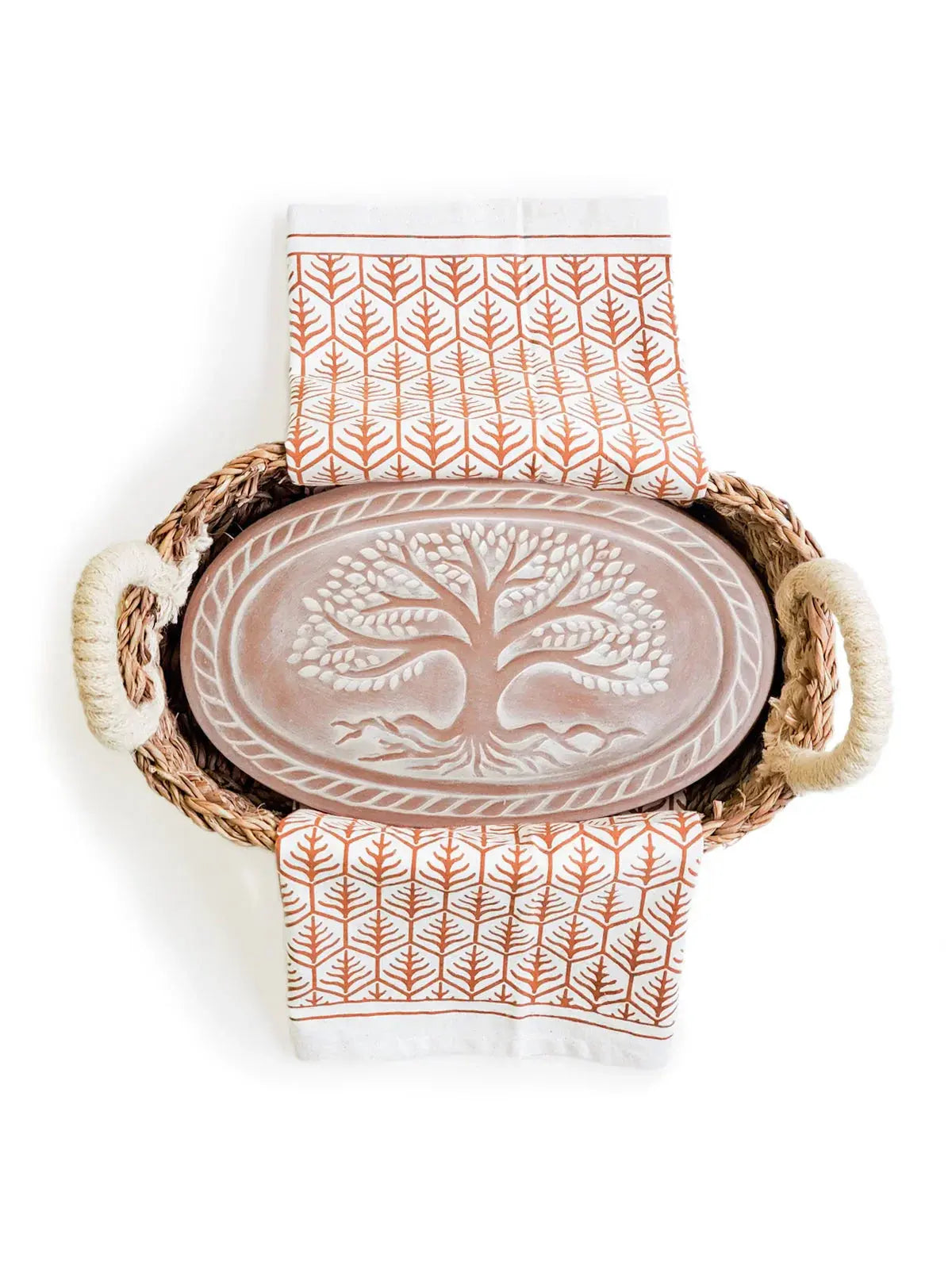 Woven basket with tree of life tray and leaf-patterned kitchen towels, cozy farmhouse decor