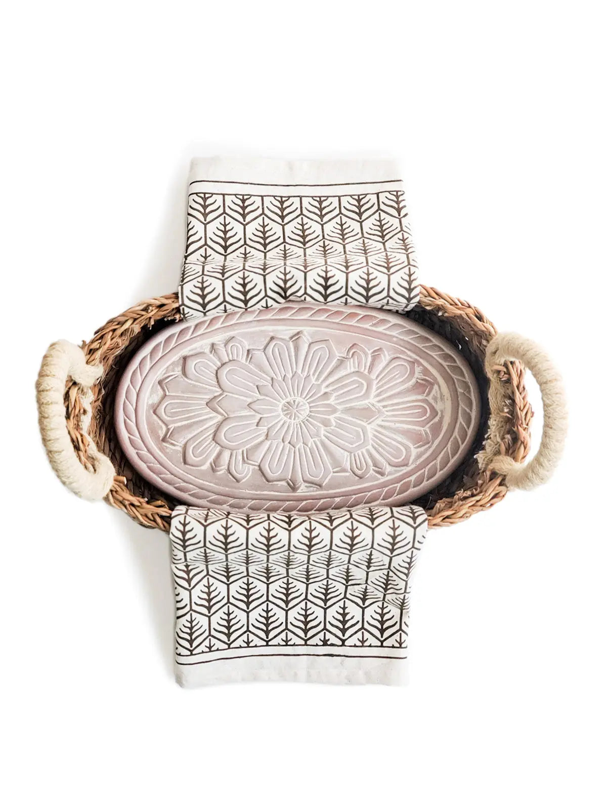 Woven basket with floral ceramic tray and leaf-patterned towels for cozy farmhouse bathroom decor