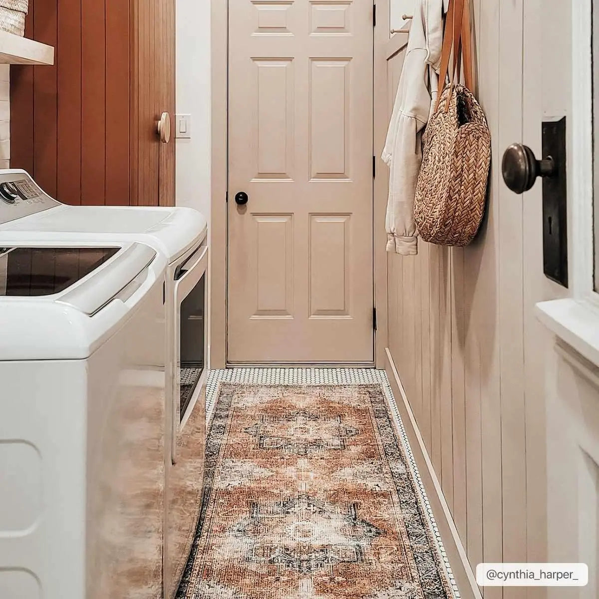 Cozy farmhouse laundry room with vintage rug, white appliances, and woven basket decor