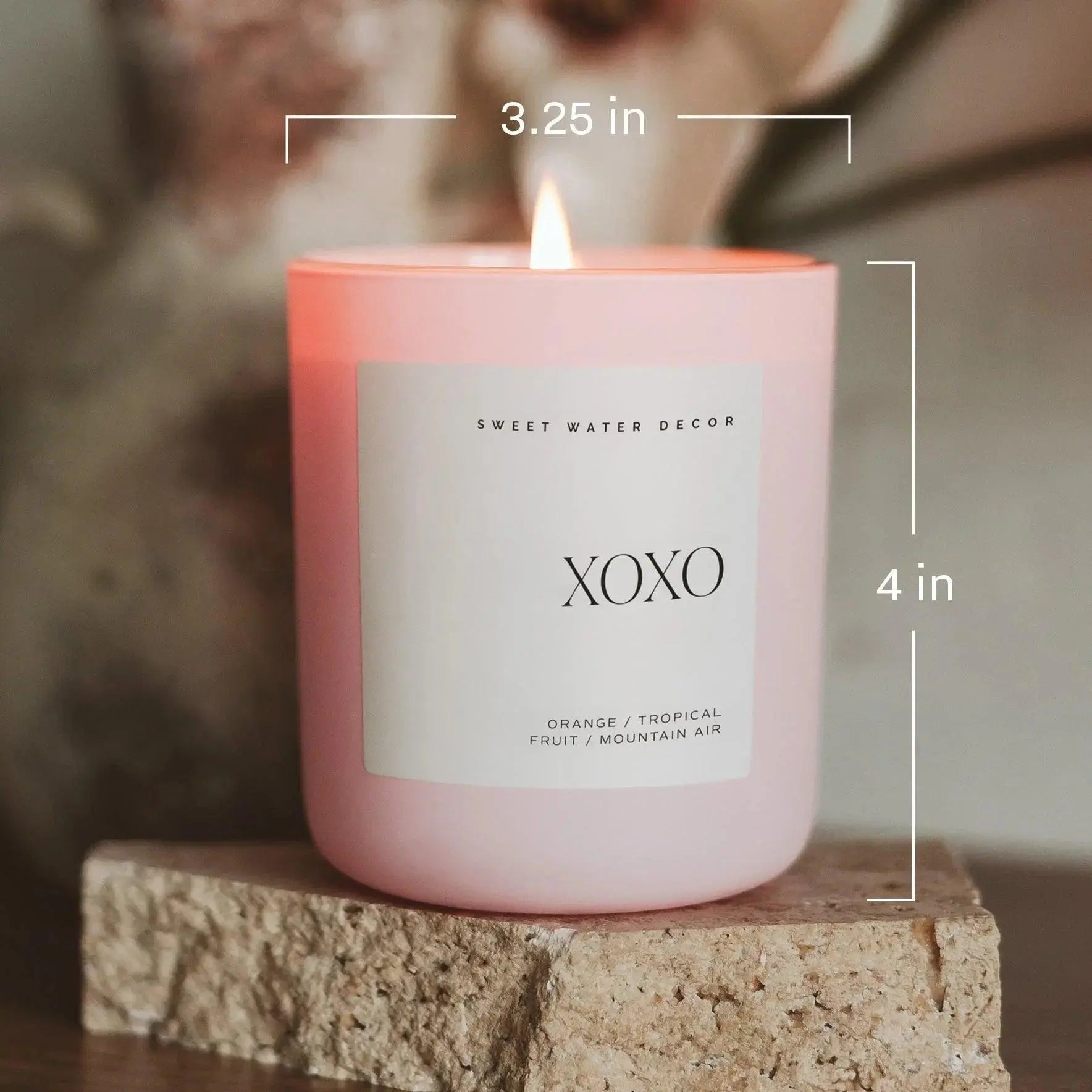 Pink XOXO scented candle with orange tropical fruit notes, cozy home decor, 4 inches tall