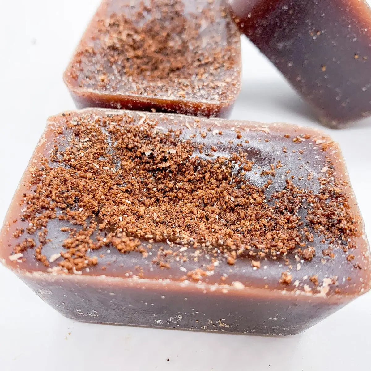Close-up of a block of chocolate soap with cocoa powder on a white background