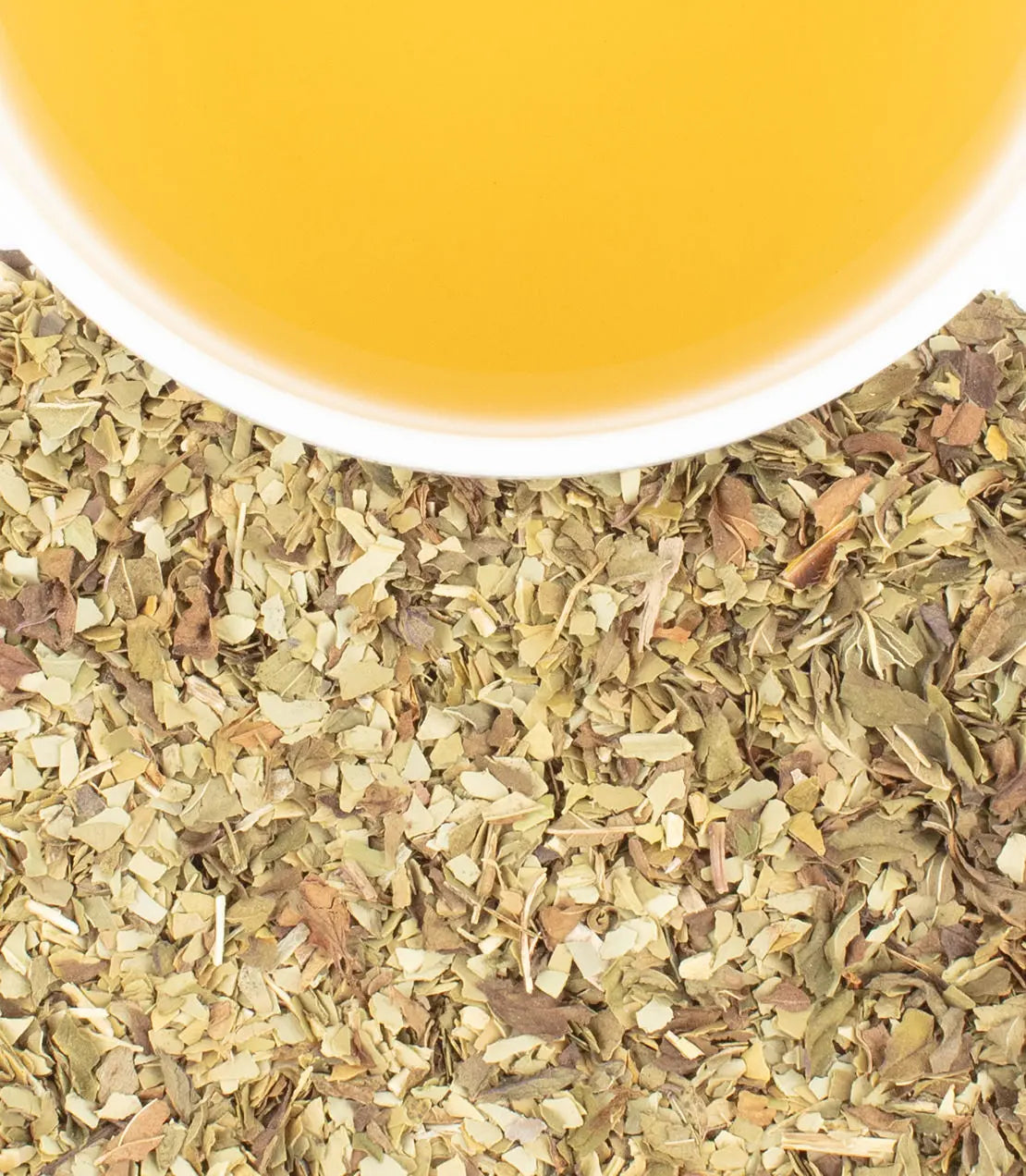 Dry herbs with a cup of tea in the background