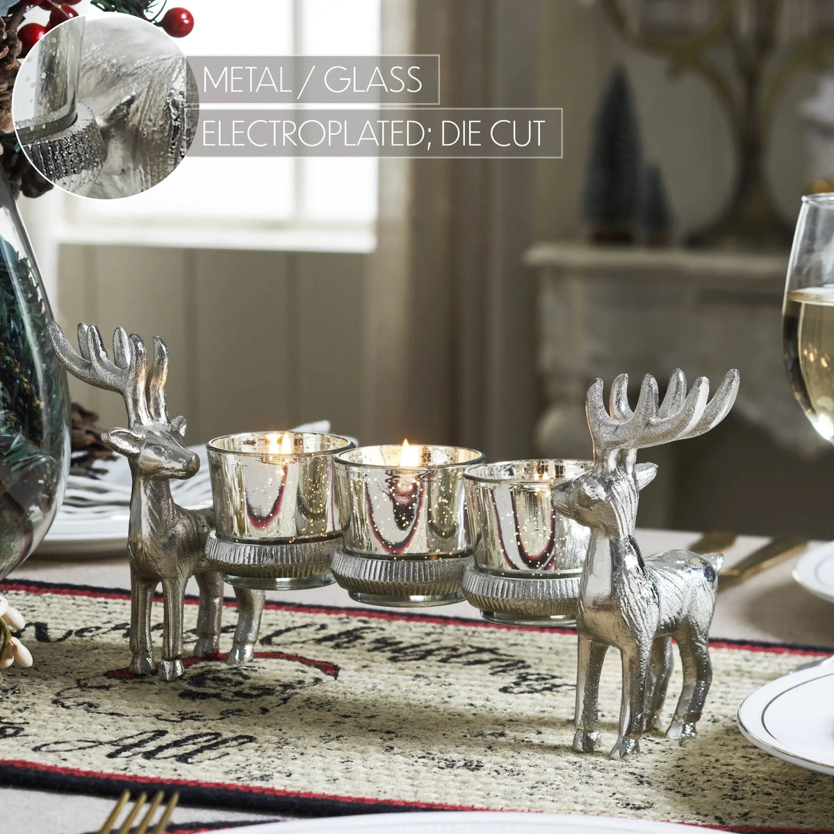 Decorative candle holders shaped like deer on a table with a glass of wine.