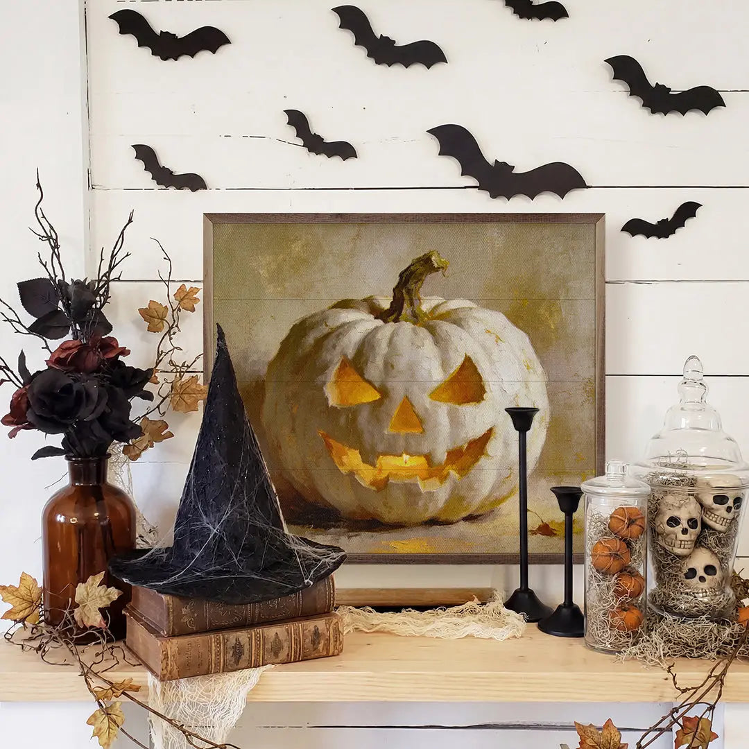 Halloween-themed decor with a carved pumpkin, black hat, and decorative items on a wooden surface.