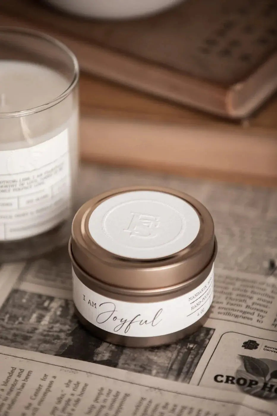 I Am Joyful scented candle in rose gold tin, cozy farmhouse decor with vintage newspaper backdrop