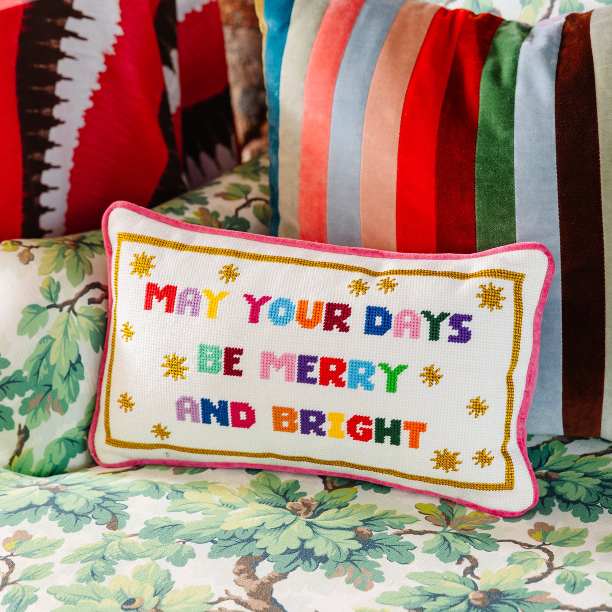 Decorative pillow with colorful text on a patterned sofa
