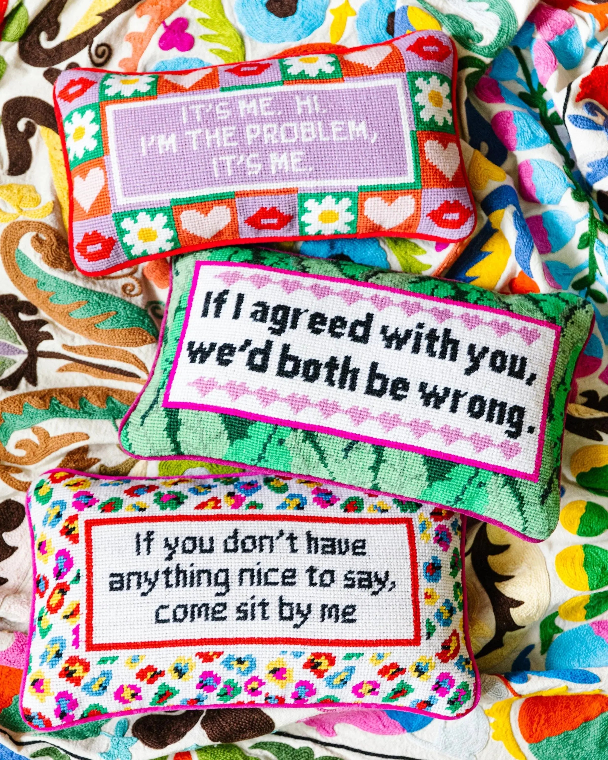 Colorful pillows with humorous text on a patterned background