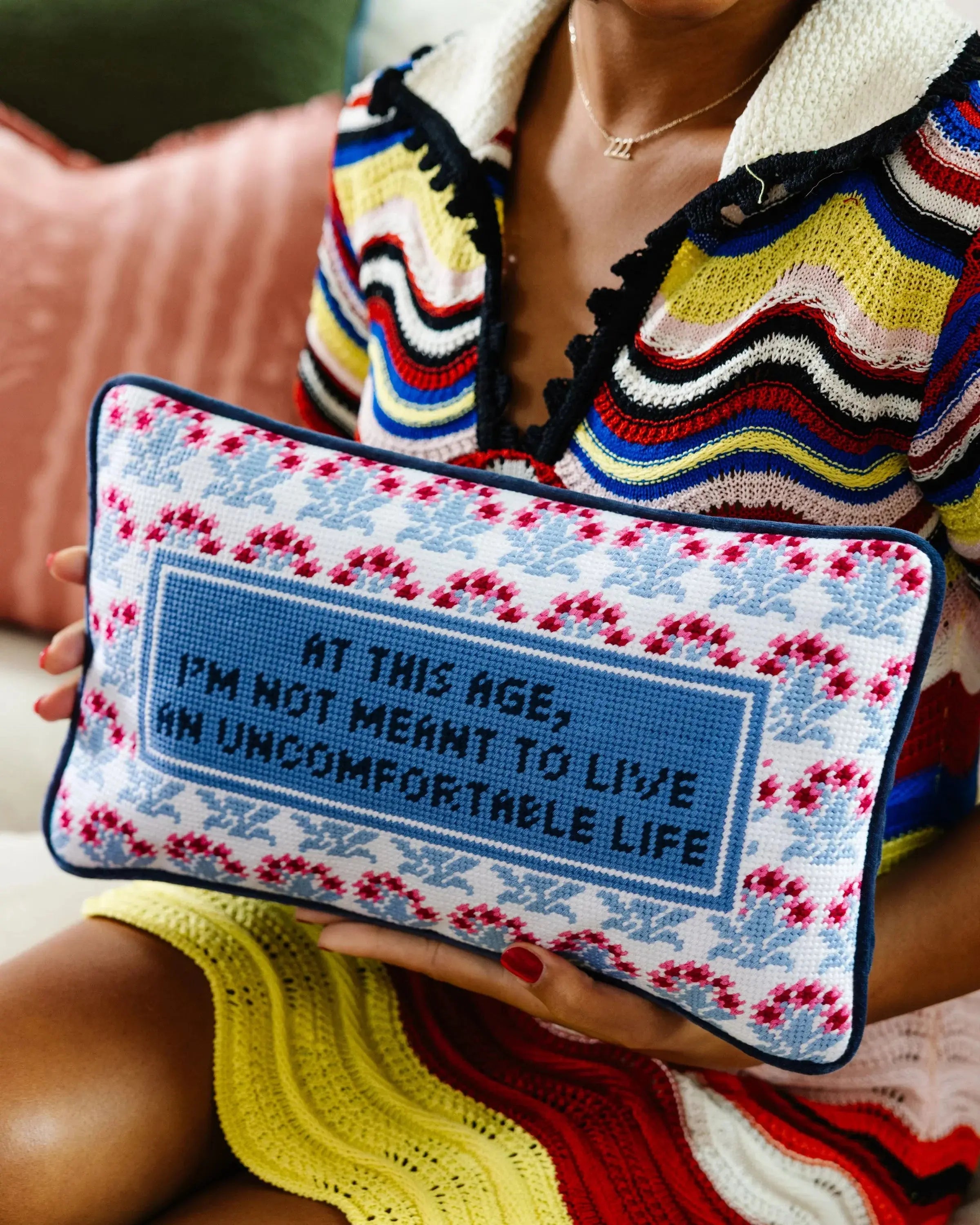 Cozy needlepoint pillow with quote 'At this age, I'm not meant to live an uncomfortable life' in farmhouse style decor