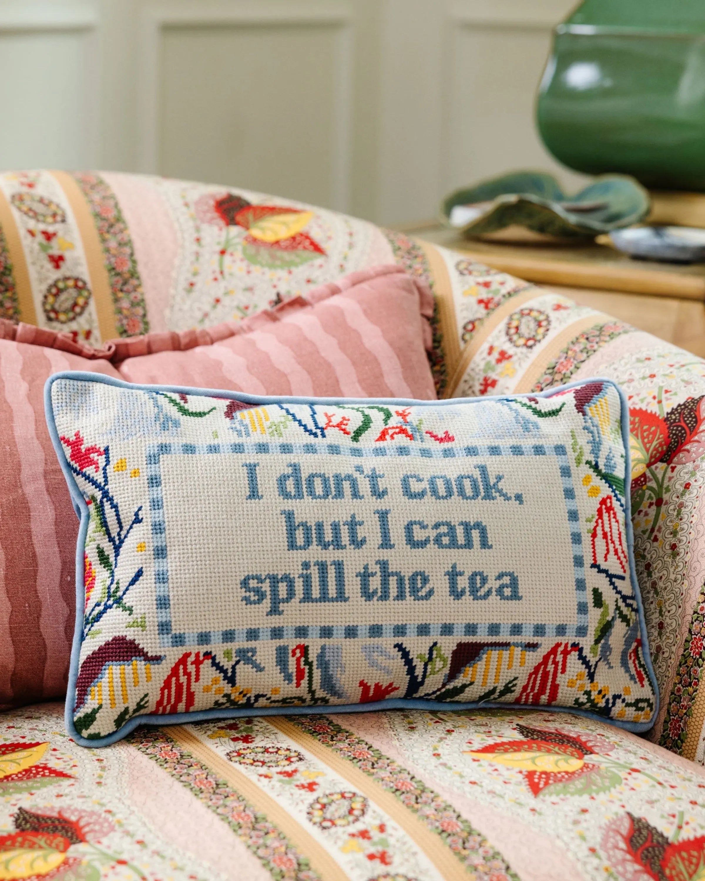 Decorative pillow with text on a floral-patterned couch