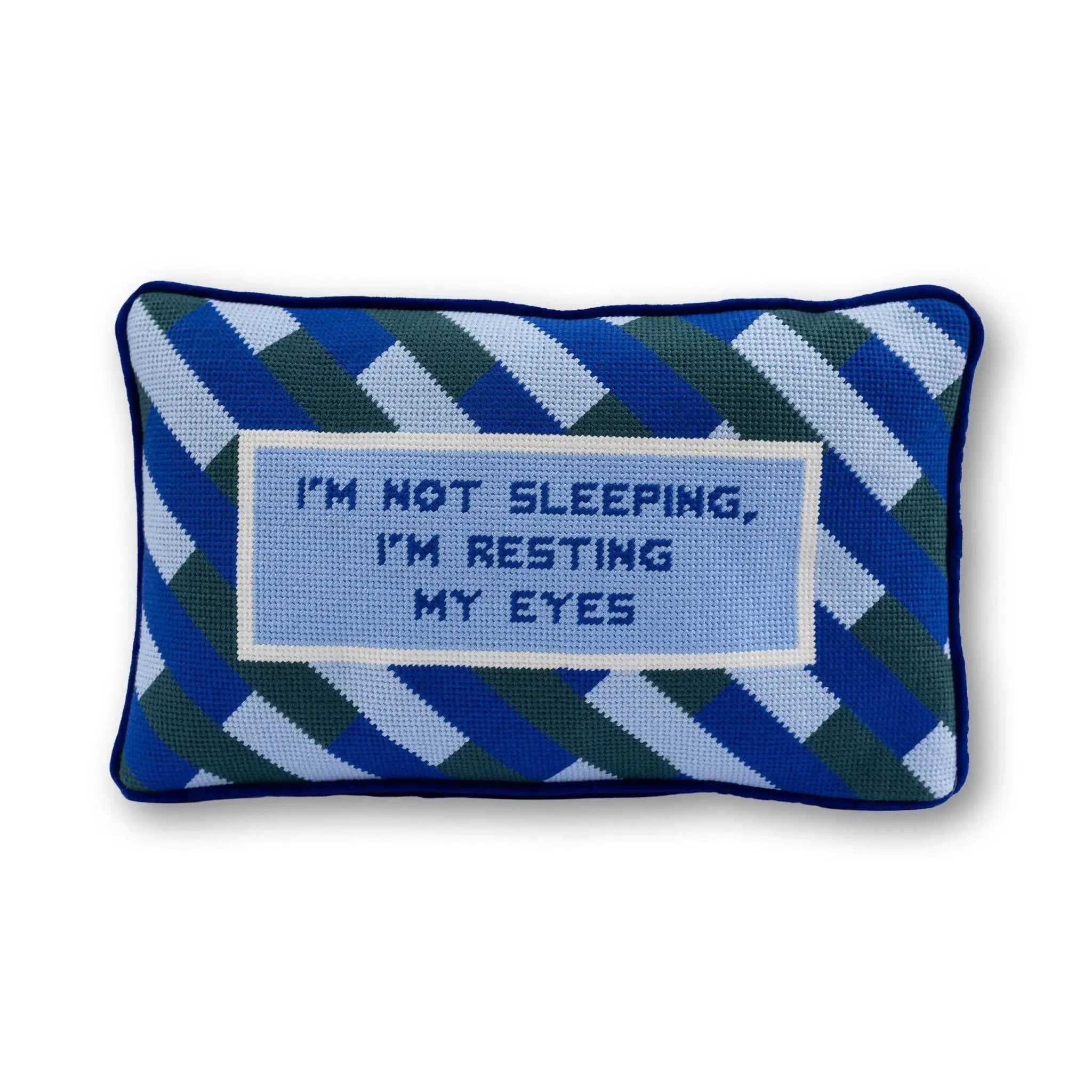 Decorative pillow with text 'I'm not sleeping, I'm resting my eyes' on a white background