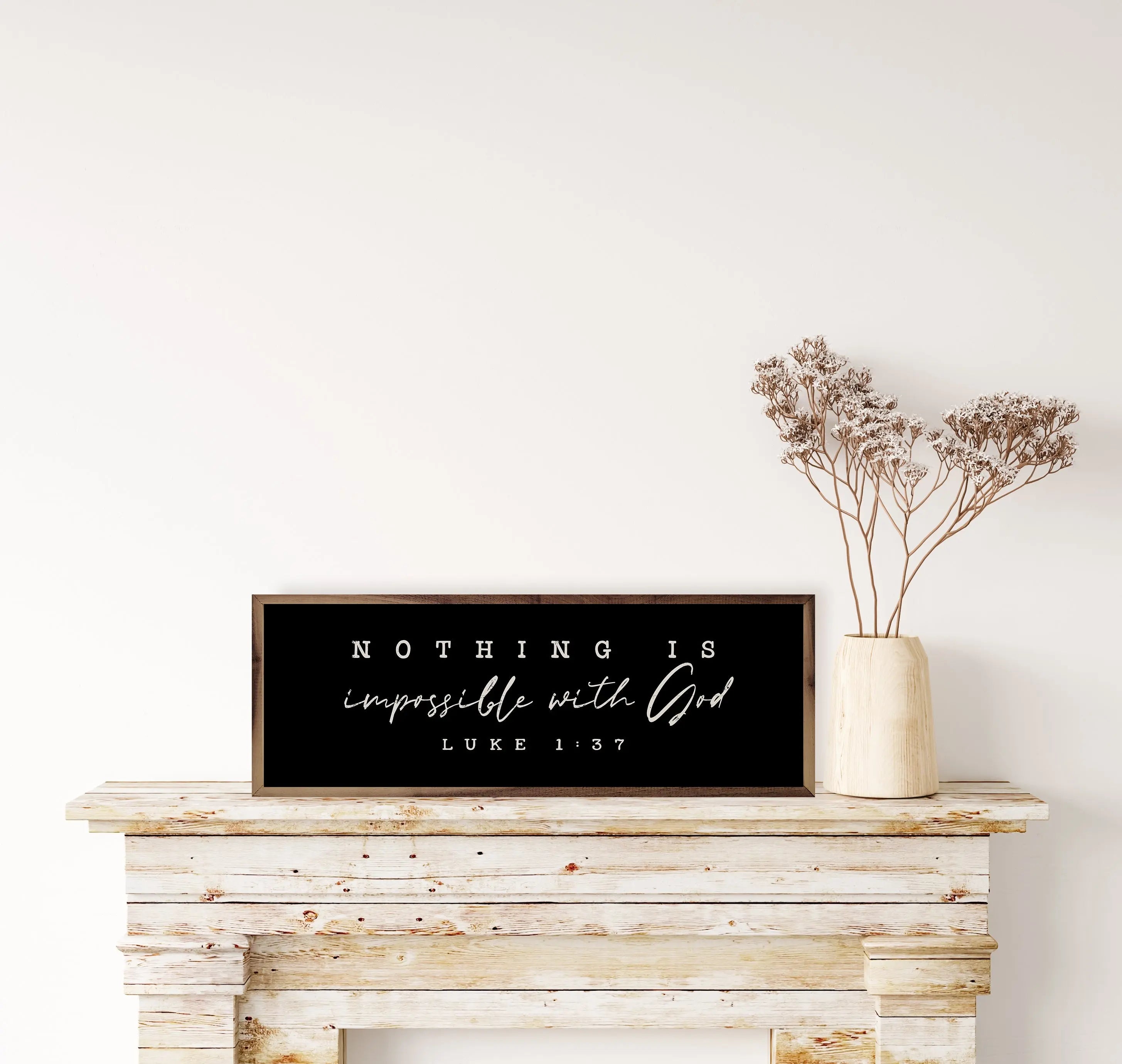 Decorative sign with inspirational quote on a wooden mantelpiece with a vase of dried flowers.